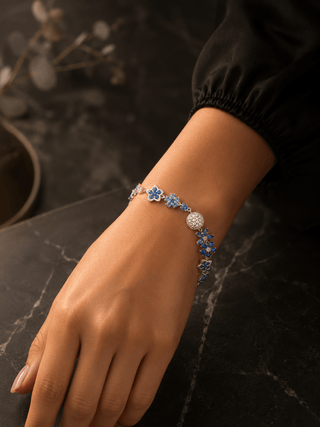 Bracelet with blue floral beads on a wrist against a dark background